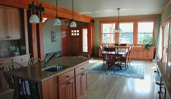 A kitchen with wood floors and a dining room table.