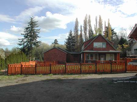 A red house with a wooden fence around it.