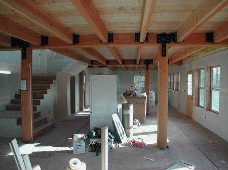 A room with some wooden beams and a refrigerator