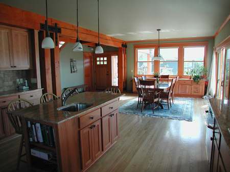 A kitchen with wood floors and wooden cabinets.